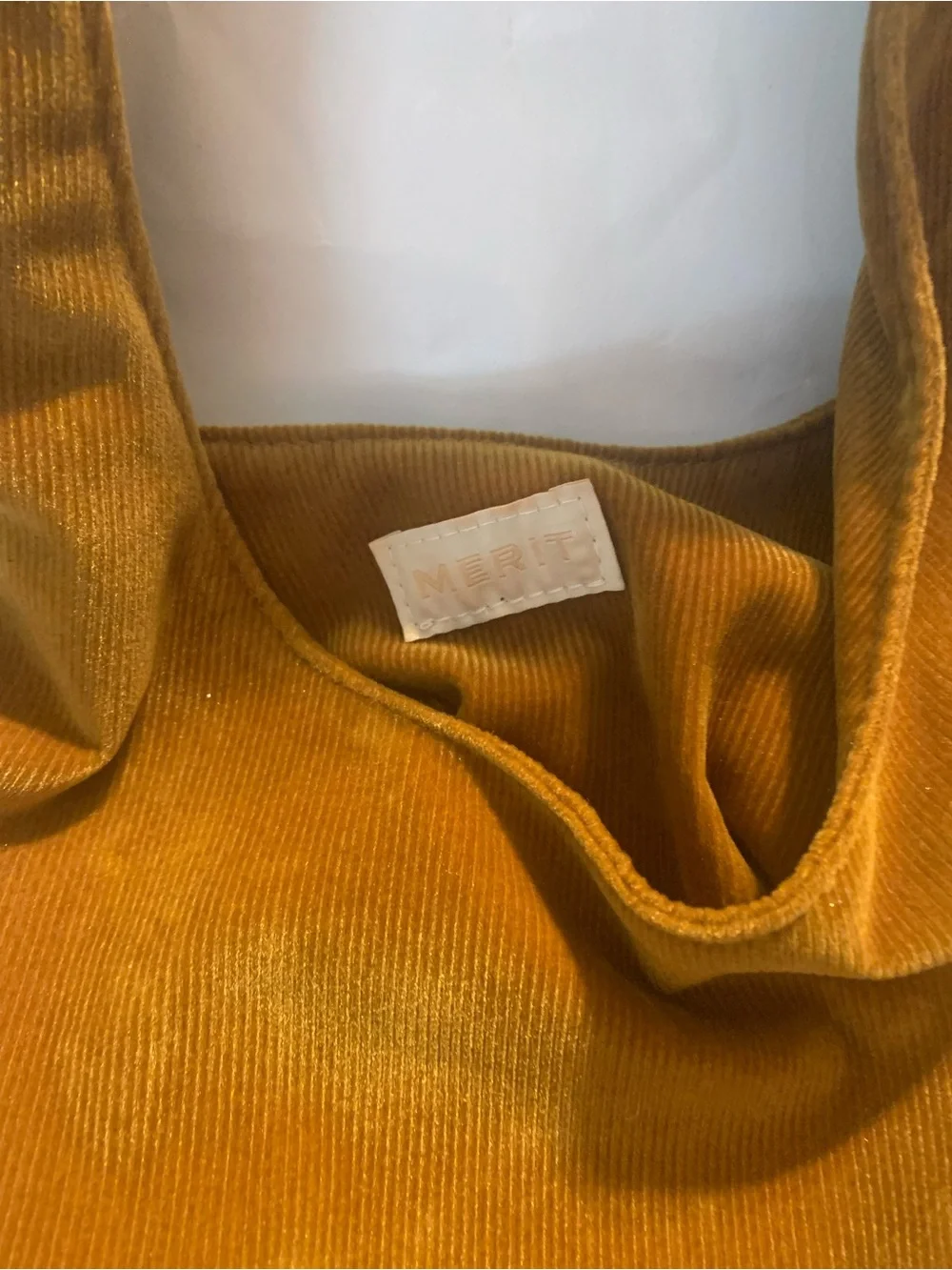 Merit Beauty Signature Bag in a golden brown or camel corduroy material